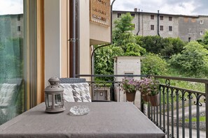 A balcony with a table, a lantern, and potted plants. - Studio Apartment 'G and B Apartments Vanessa' with Mountain View, Shared Pool and Wi-Fi (Tignale sul Garda)