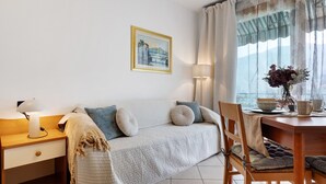 A cozy room with a sofa, a wooden table, a lamp, and a painting on the wall.