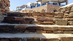 A stone staircase leading to a building with blue railings and white walls.