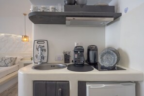 A compact kitchenette with a Bosch coffee maker, a sink, and a compact refrigerator.