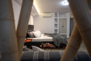A bedroom with a bed, bedside table, lamp, and a wardrobe.