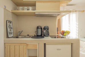 Una kitchenette equipada con cafetera, tostadora, pileta y refrigerador pequeño.