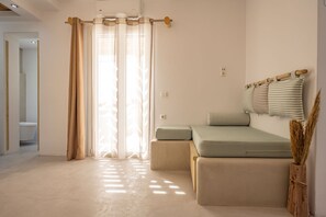 Un dormitorio moderno con sofá cama, una ventana con cortinas translúcidas, una mesita de noche y una barra de cortina fijada a la pared.