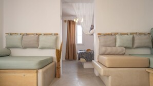 Une chambre avec deux lits, une petite table et une fenêtre avec des rideaux.