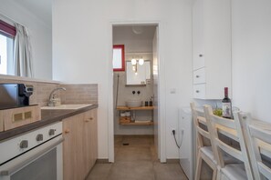 Uma cozinha compacta com fogão, pia e armários de madeira.