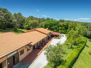 Ein Gebäude mit einem Ziegeldach, einer überdachten Terrasse und Blick auf eine grüne Landschaft.