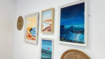 A wall with four framed artworks and a woven basket.