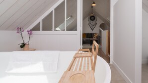 A modern bedroom with a sloped ceiling, a wooden bed frame, a white wall, and a hanging dreamcatcher. - Ker mam - Belle-Île en Mer, electric bikes at your disposal (Sauzon)