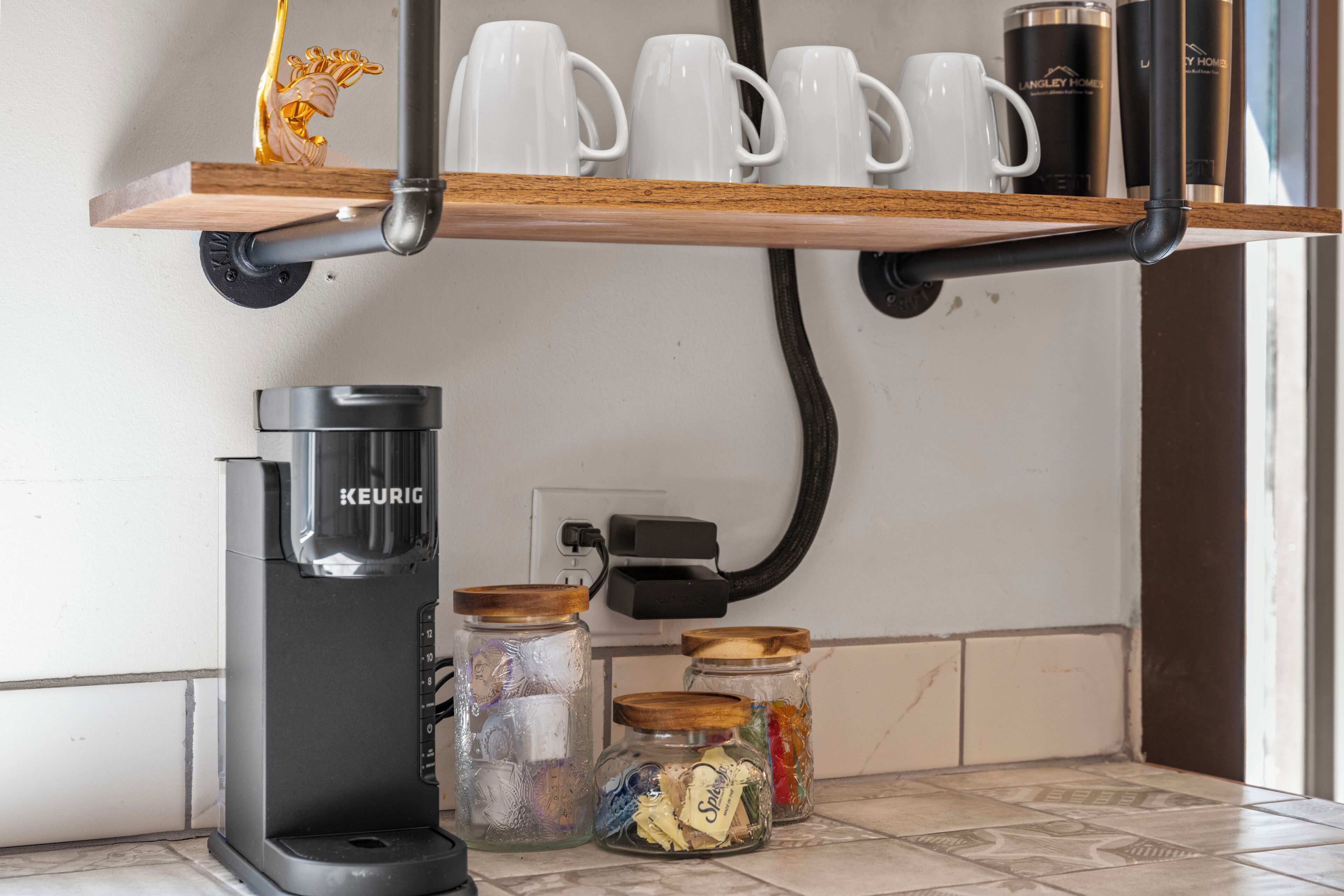 Eine Kaffeemaschine, Gläser und Tassen auf einem Regal.