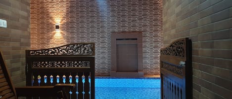 Una piscina al aire libre, sillones reclinables de piscina