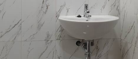 Ein Badezimmer mit Waschbecken und Duschbereich.