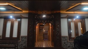 Une entrée avec une arche en bois, un escalier et un banc.