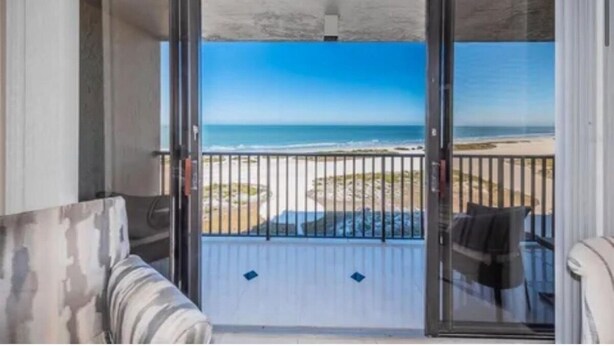 A balcony with a view of the beach and ocean.