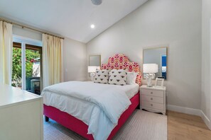 Relax in this serene bedroom with a large bed, bedside table, and mirror.
