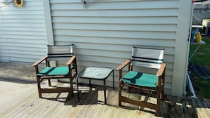 Two wooden chairs with green cushions and a small table on a wooden deck. - Cozy, comfortable and close to CBD (Whakatane)