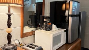 A kitchenette with a microwave, toaster, coffee maker, and refrigerator. - Athabasca Hillside Motel (Athabasca)