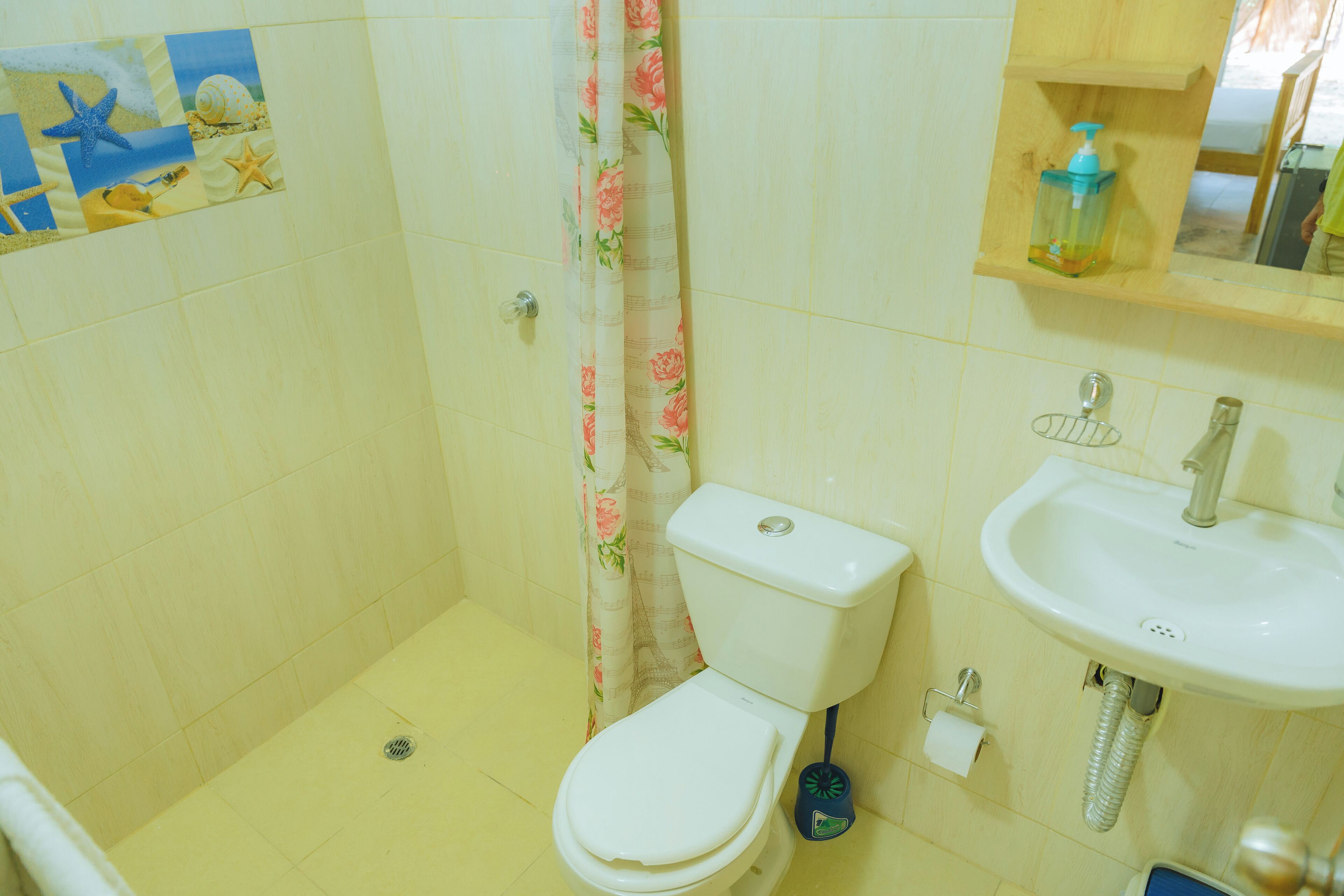 A bathroom with a toilet, sink, and shower curtain.