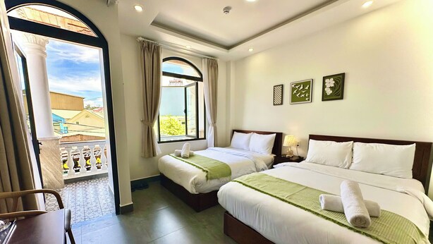 A hotel room with two beds, a balcony, and a view of buildings. - Amelia House - Boutique Hotel (Lam Vien - Da Lat)