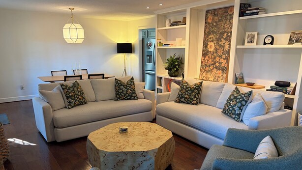 A living room with two sofas, a coffee table, and a bookshelf.