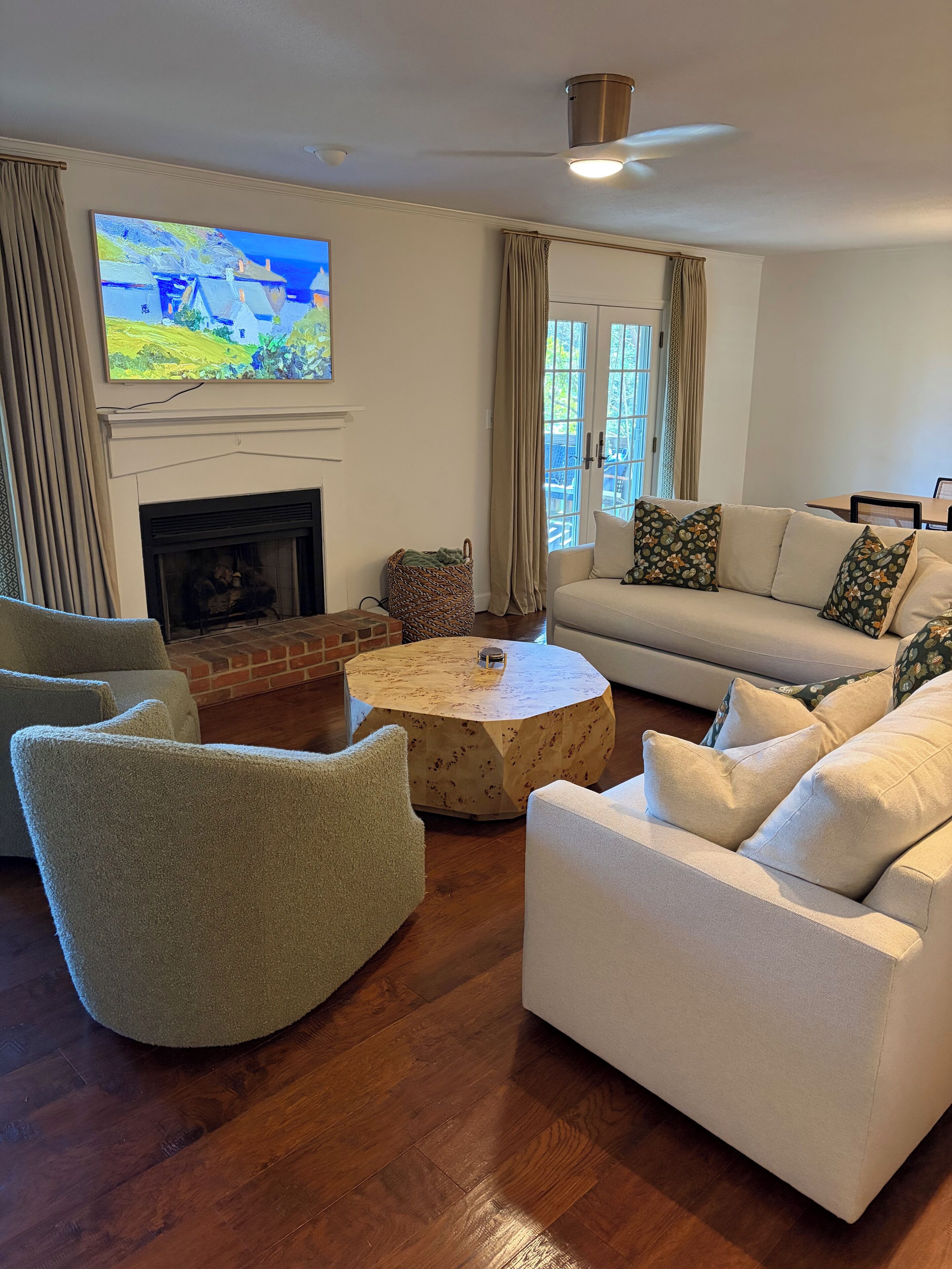 A living room with a fireplace, a television, a sofa, and a round coffee table.