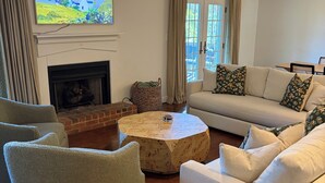 A living room with a fireplace, a television, a sofa, and a round coffee table.