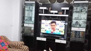Un salon comprenant un téléviseur, un canapé, une table basse et des objets de décoration.