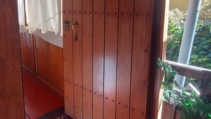 Une porte en bois avec un loquet en métal et un rideau blanc.