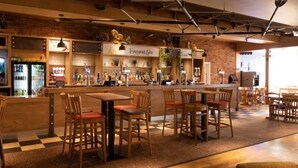 Ein gemütliches Restaurant mit Holztischen, einer Bar und einer sichtbaren Speisekarte.