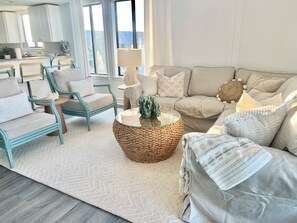 A modern living room with a sofa, chairs, a coffee table, and a rug.