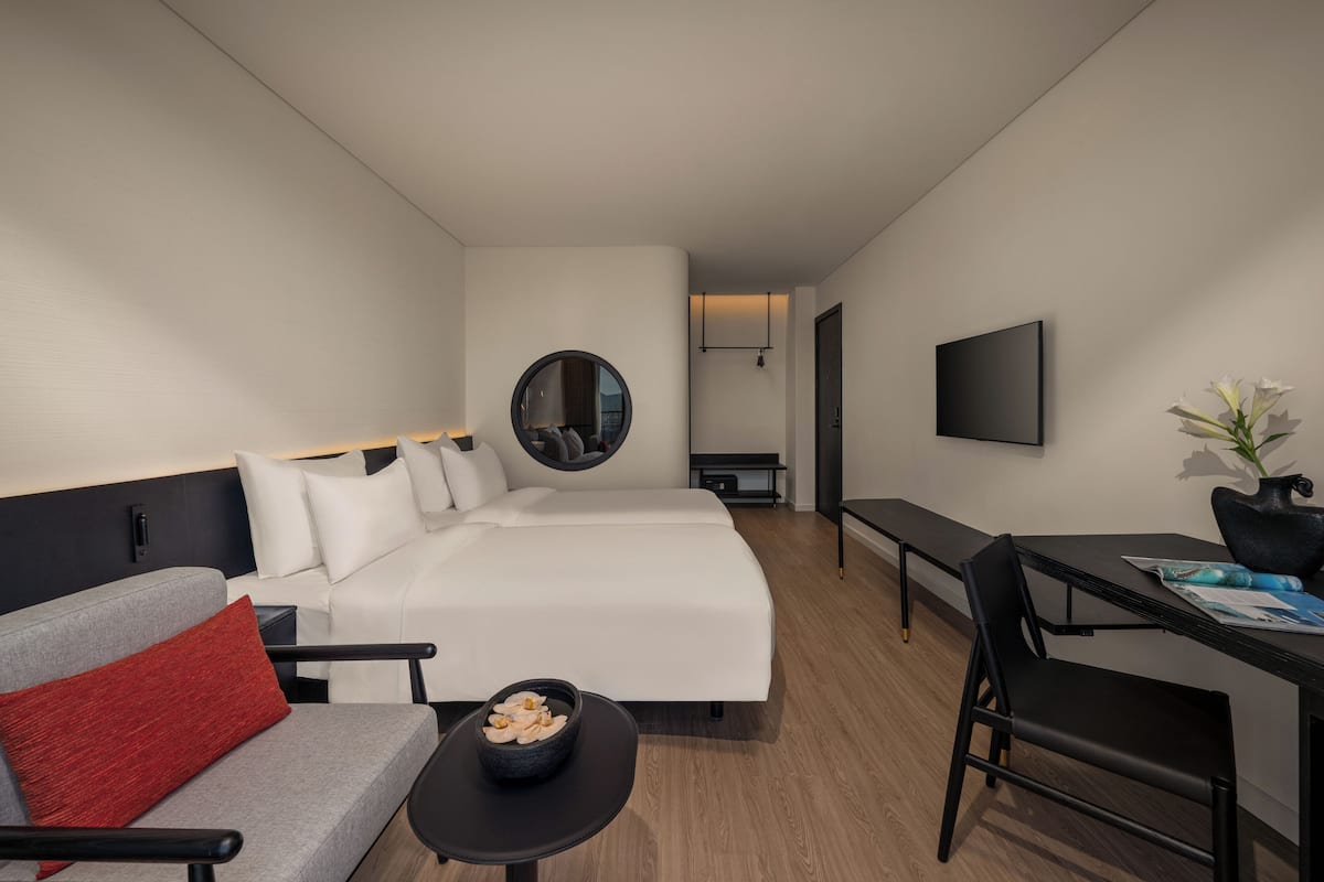 Une chambre d’hôtel moderne équipée d’un lit, d’un canapé, d’un bureau et d’une télévision.