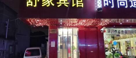 A hotel entrance with a red facade and a visible room number.