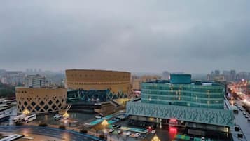 A cityscape with modern buildings, a roundabout, and a busy road with vehicles.