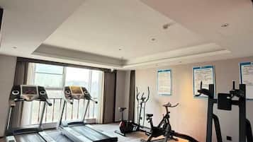 A hotel gym with treadmills, stationary bikes, and exercise equipment.