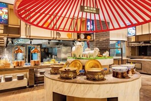 Et restaurantinteriør med en central ø, en rød parasolkonstruktion og et skilt, der angiver navnet.
