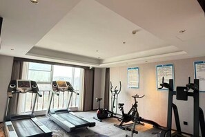 A gym with treadmills, stationary bikes, and a rowing machine.