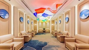 A hotel lobby with a central seating area, a patterned carpet, and wall-mounted artwork. - Ordos Taihua Langjing Hotel (Ordos)