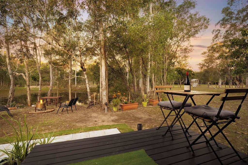 Un espace extérieur aménagé avec une table et des chaises, un foyer et des plantes en pot.