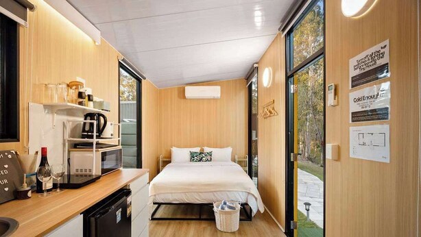 A compact hotel room with a bed, kitchenette, and a view of the outdoors. - JJJ's Ranch Farm 1 by Tiny Away (South Kolan)