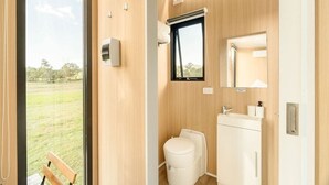 Ein modernes Badezimmer mit Toilette, Waschbecken und Fenster.