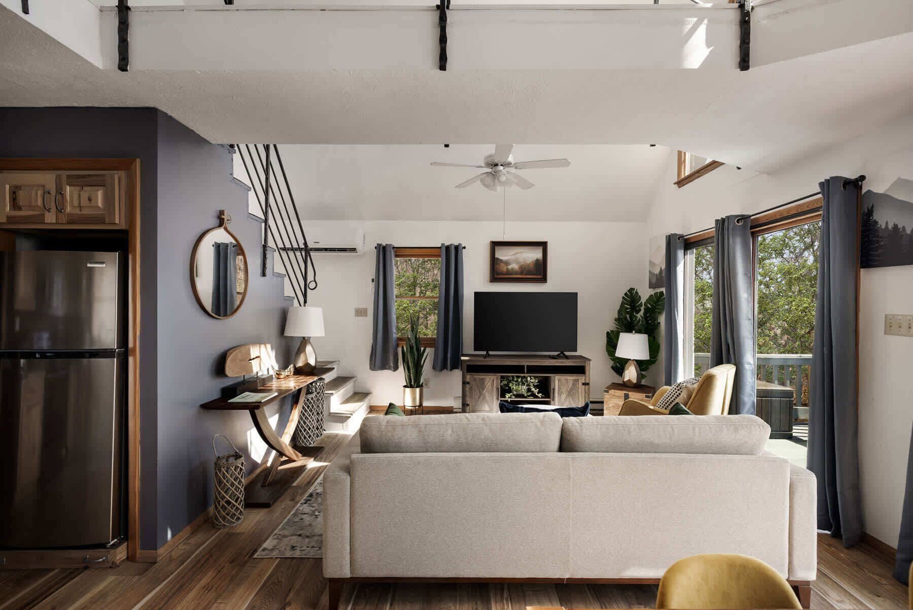 A modern living room with a sofa, TV, and dining area.