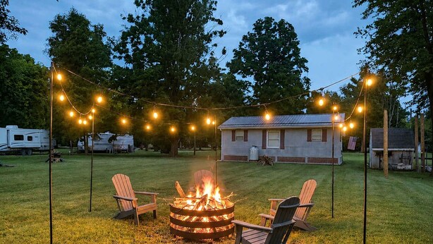 A fire pit with chairs, string lights, and a house in the background. - Wood Stove, Fire Pit, Kayaks - 2 Min Walk to River (Springfield)