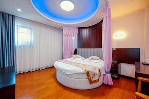 A modern bedroom with a round bed, a desk, and a ceiling light. - Fuchun Ju Yayue Hotel (Wusongkou International Cruise Port) (Shanghai)