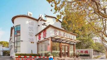 A hotel with a traditional architectural style, featuring a curved facade and a prominent entrance with glass doors.