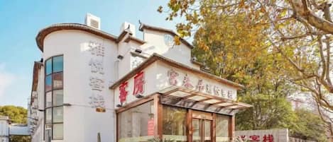 A hotel with a traditional architectural style, featuring a curved facade and a prominent entrance with glass doors.