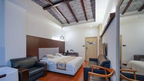 Una habitación de hotel moderna con cama, sofá, escritorio y una silla.