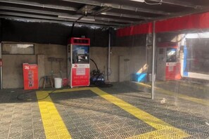 A gas station with a red fuel pump, a yellow safety line on the floor, and a red sign with white text. - Youyou Boutique Hotel (Xiong County Government Branch) (Xiong County)