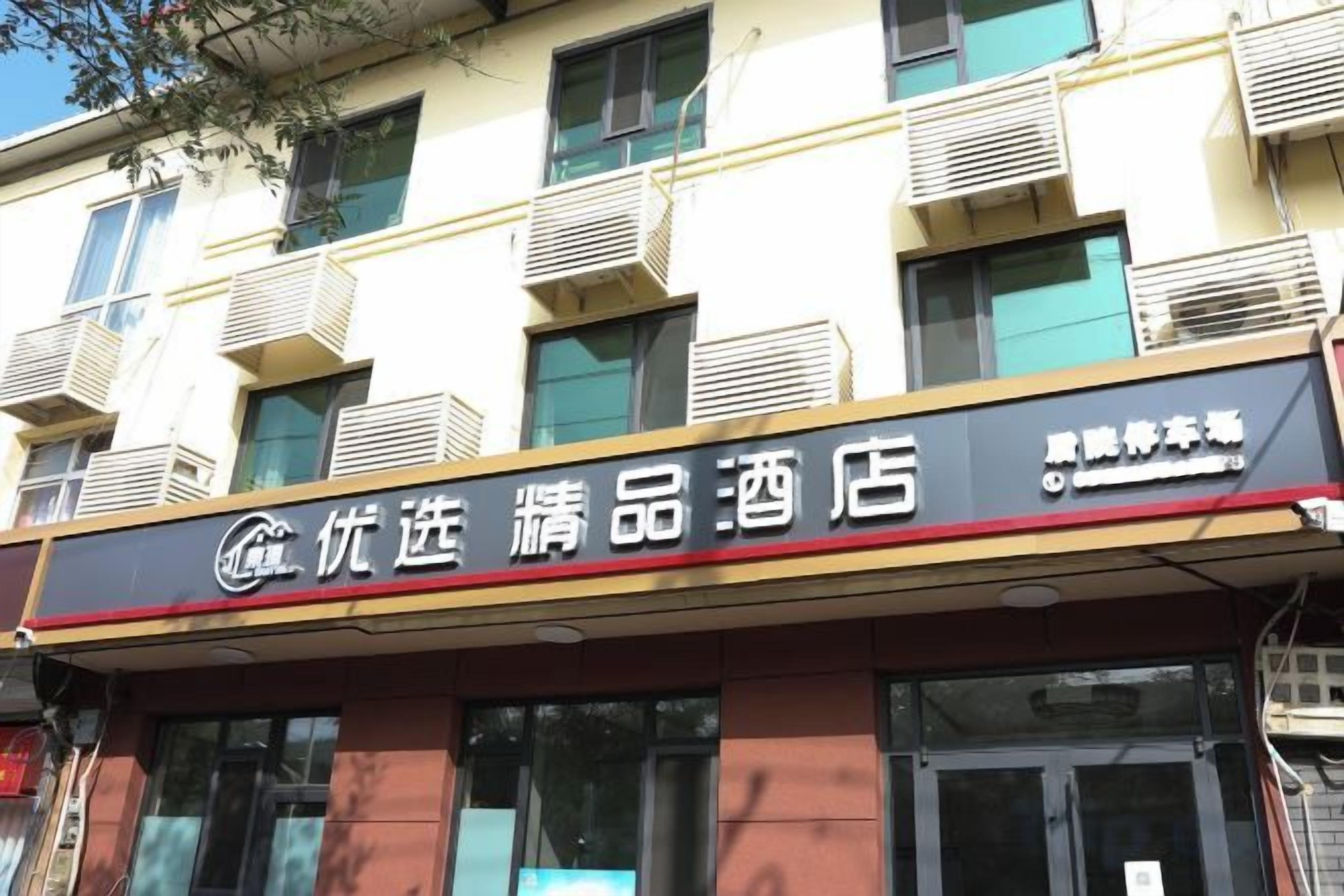 A hotel with a signboard indicating it is a '优选精品酒店' (Premium Hotel).