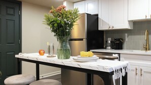 A kitchen with a marble countertop, a vase with flowers, a fruit bowl, and a coffee maker. - Spa Bath 20 Min to  Lincoln Financial Field + Dedicated Parking + City Access (Philadelphia)