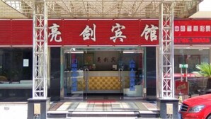 Ingresso di un hotel con tenda rossa e insegna.