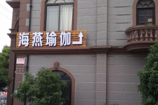 A building with a sign that reads '海燕瑞加' and an arrow pointing upwards. - Liangjian Hotel Shanghai (Shanghai)